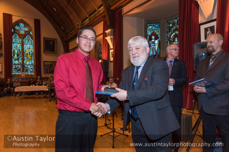 Councillor Peter Campbell hans a gift to Penticton Indian youth at Civic Reception at Lerwick Town Hall, Shetland for the Spirit Dancer Shetland Committee exchange visit by young people from the Osoyoos Indian and Penticton Indian Bands from Canada to Shetland on 27 April 2015