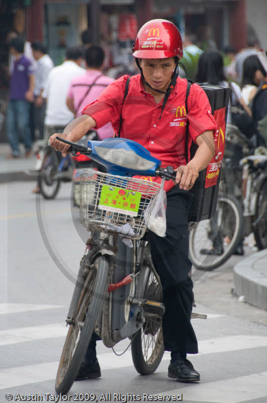 McDonalds delivery boy in the area bounded by Yu Bazaar, Cang Bao Lu, Old City Mosque and Chonxiangge Nunnery, Shanghai